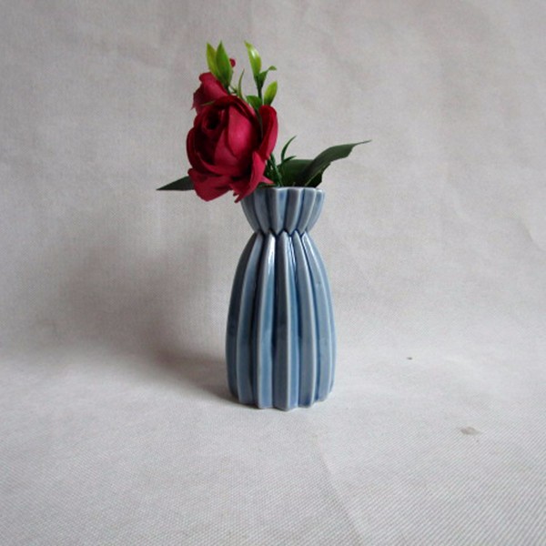 vase en porcelaine fleur sur vitrage bleu clair 